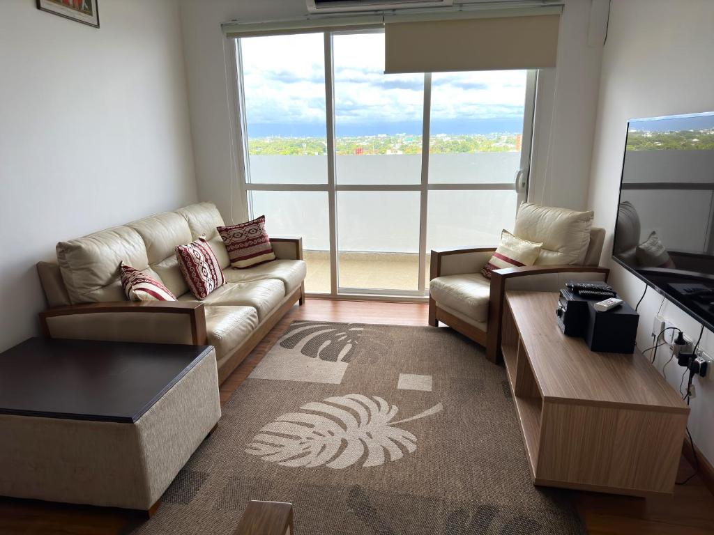 - un salon avec un canapé et une grande fenêtre dans l'établissement Rush Resident Mount Lavinia, à Dehiwala-Mont Lavinia