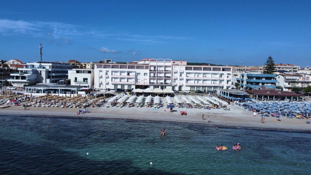 een groep mensen in het water op een strand bij Hotel San Marco in Alghero