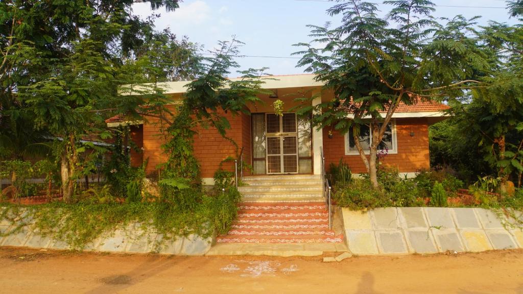 a small brick house with stairs in front of it at DIVINE HOME in Mahisama