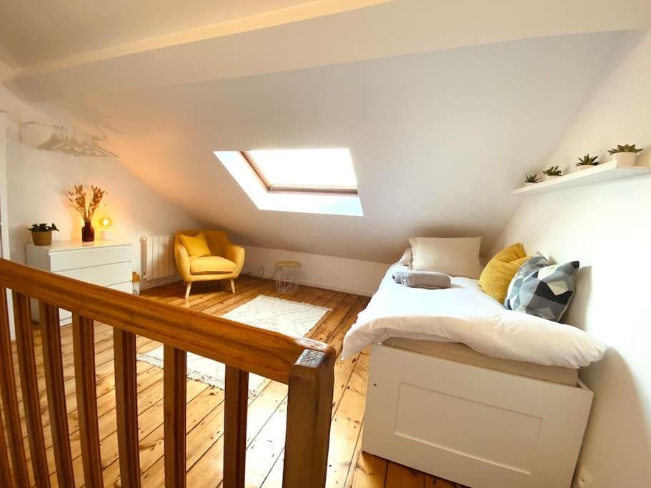 een slaapkamer op zolder met een bed en een dakraam bij Maison LILLE 6 personnes avec Jardin in Lille