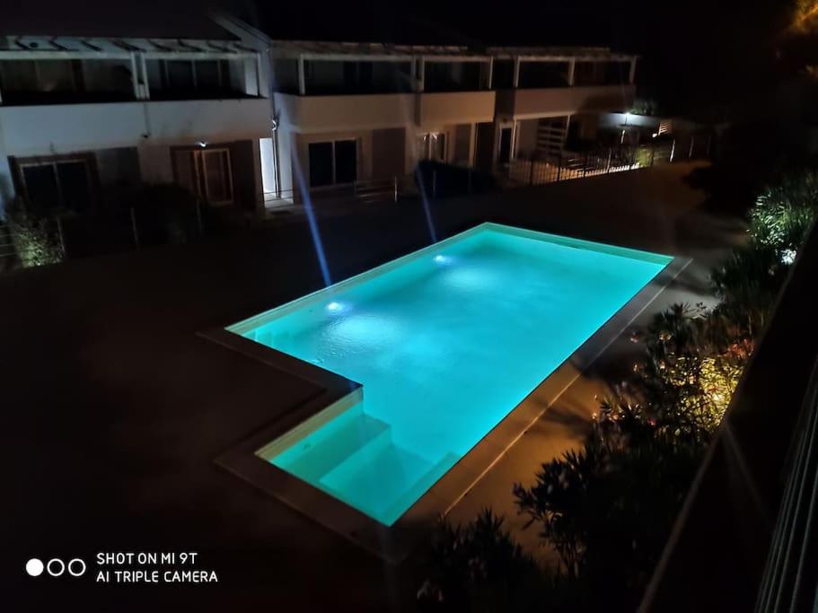 a swimming pool at night in front of a building at Casa Flo in Viddalba