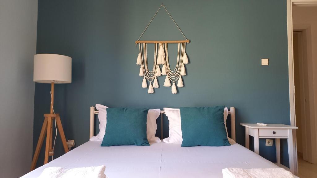 1 dormitorio con 1 cama con pared azul en Kiani Apartment, en Preveza