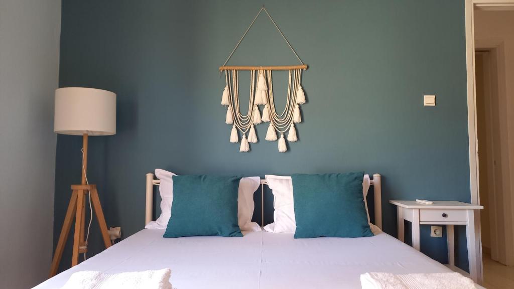 une chambre avec un lit avec un mur bleu dans l'établissement Kiani Apartment, à Prévéza