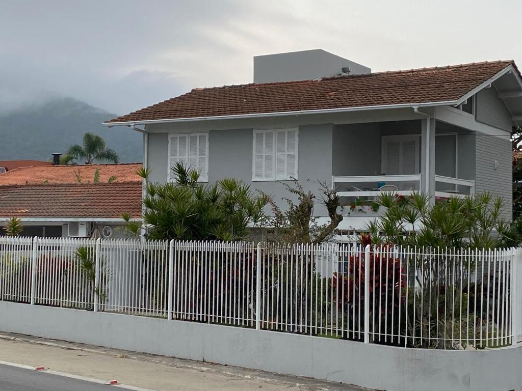 uma cerca branca em frente a uma casa em Excelente casa de praia no Cachoeira do Bom Jesus em Florianópolis
