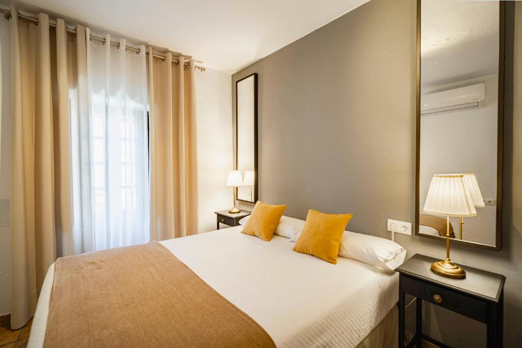 a bedroom with a large bed with yellow pillows at La Sultana de Vejer in Vejer de la Frontera