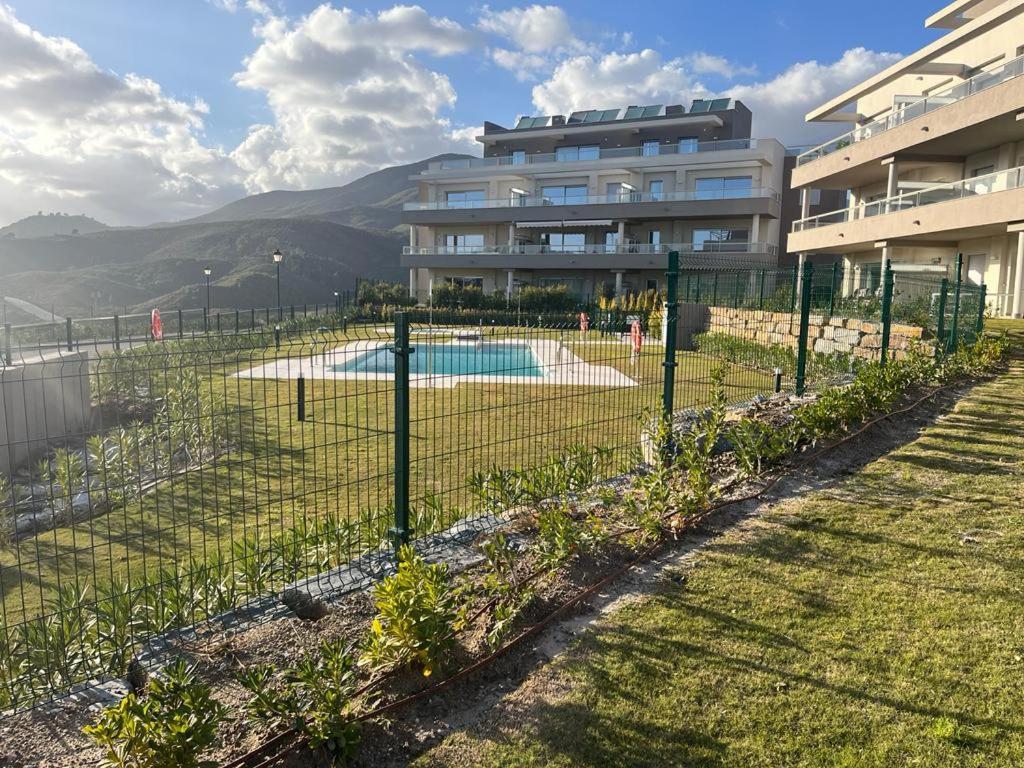 una valla con piscina frente a un edificio en La Cala de Mijas Apartment, en Málaga
