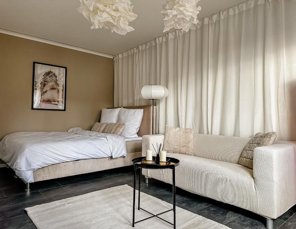 una camera con letto e divano di Joyfulhomes City Apartment a Brema