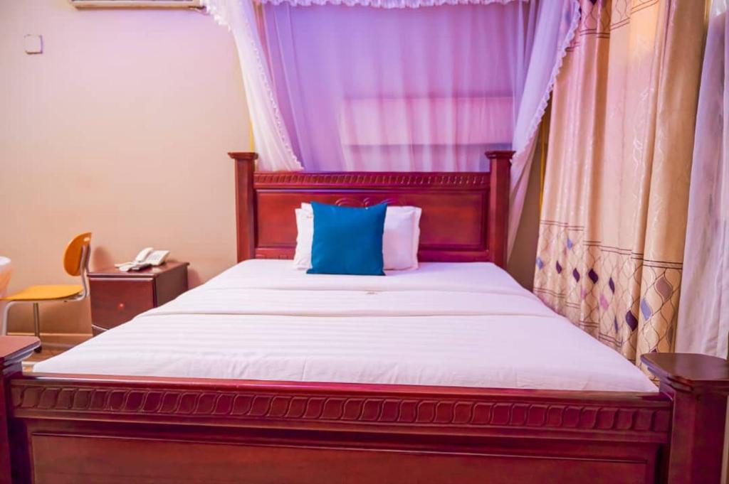 a bedroom with a bed with a blue pillow on it at Twin towers hotel in Kampala