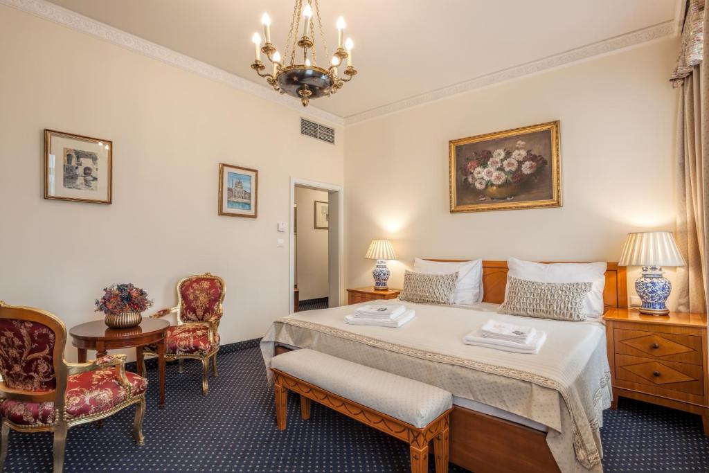 فندق أوروبا في برنو: غرفة نوم بسرير وطاولة وكراسي