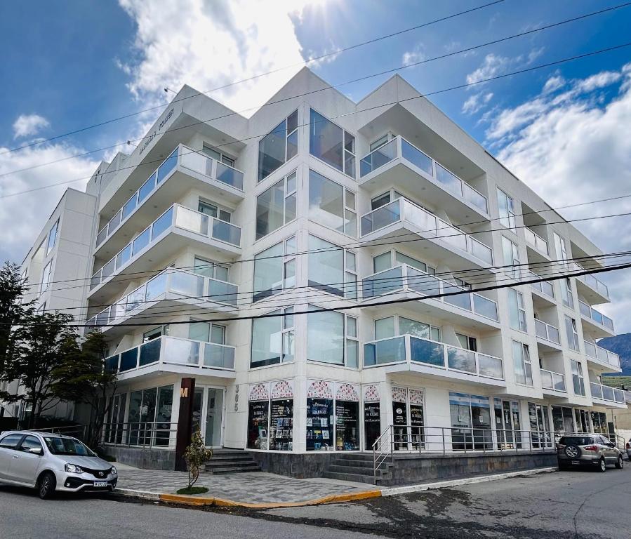 ウシュアイアにあるHappy Guest Apart 305の前に車が駐車されている白い建物