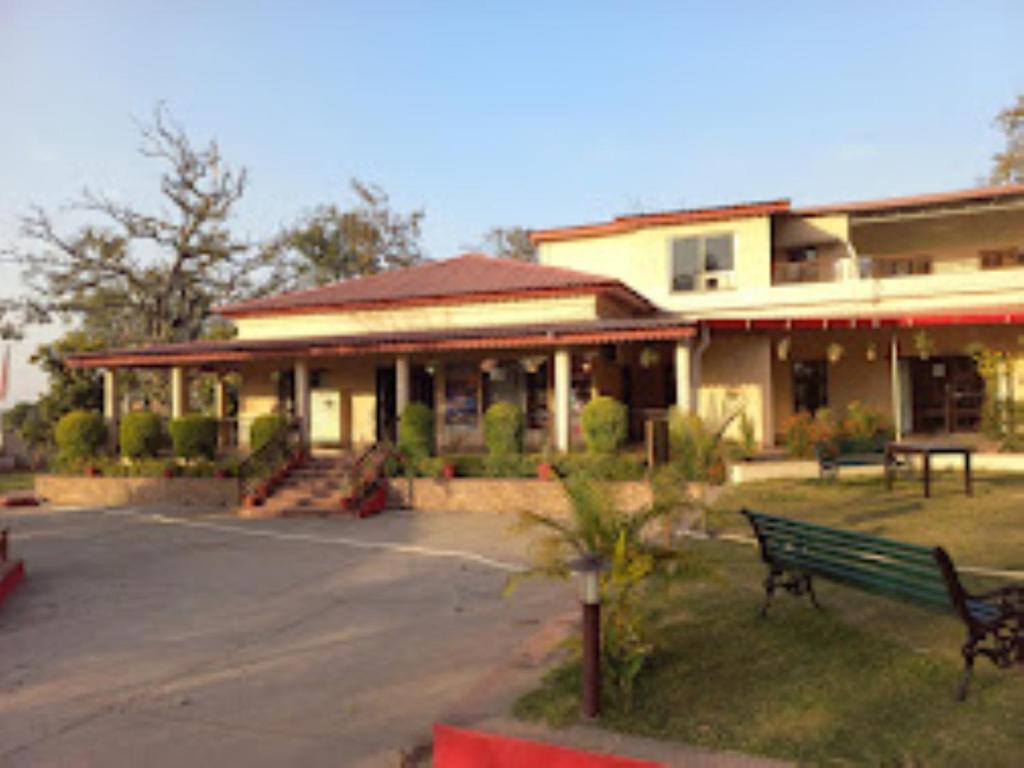 um edifício com um banco verde à sua frente em MPT Jungle Camp, Panna em Rājgarh