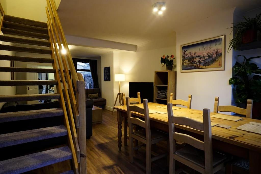 a dining room with a wooden table and chairs at 2BR Home W/ en-suite toilet, Town Centre Ipswich. in Ipswich