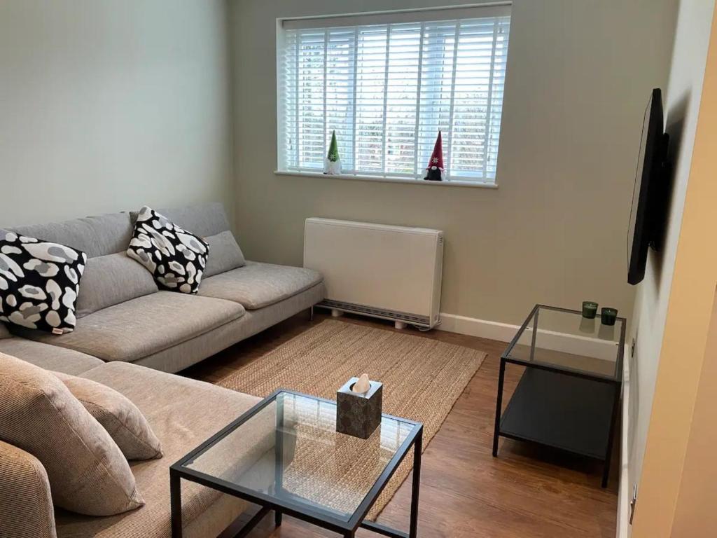uma sala de estar com um sofá e uma mesa em Pass the Keys Modern Family Friendly Flat with Parking em Rickmansworth