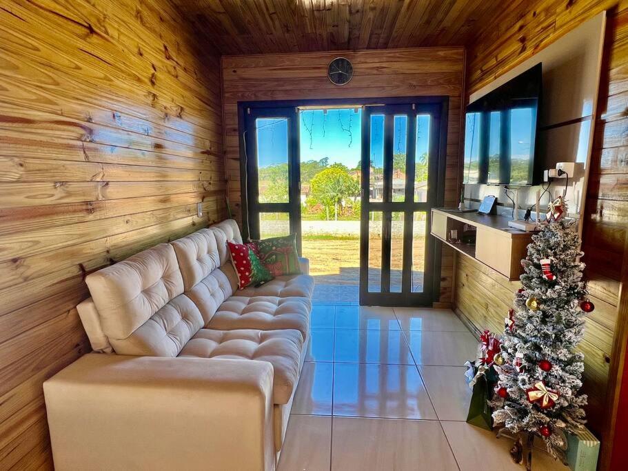 a living room with a couch and a christmas tree at Casa Bella Italia con piscina in Içara