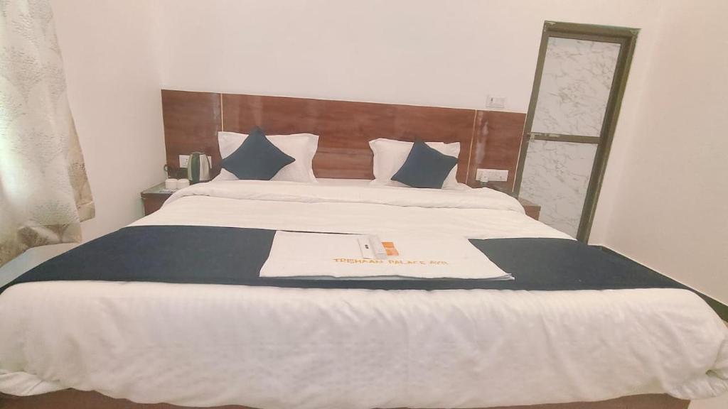 - une chambre avec un grand lit et une tête de lit en bois dans l'établissement HOTEL KANAK KUTEER, à Ayodhya