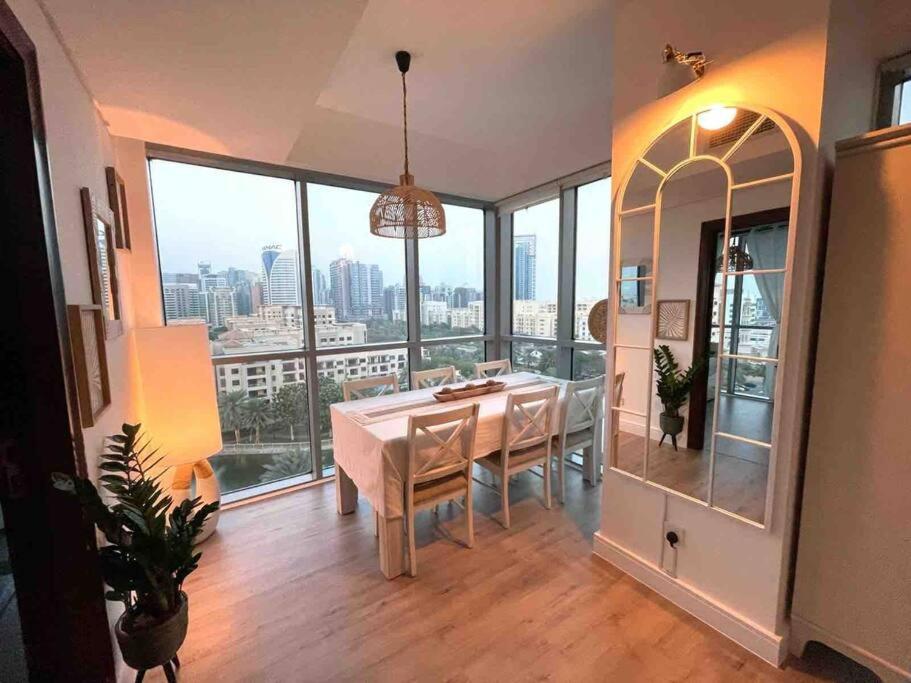 a dining room with a table and views of the city at Lakeside Bliss Home in Dubai