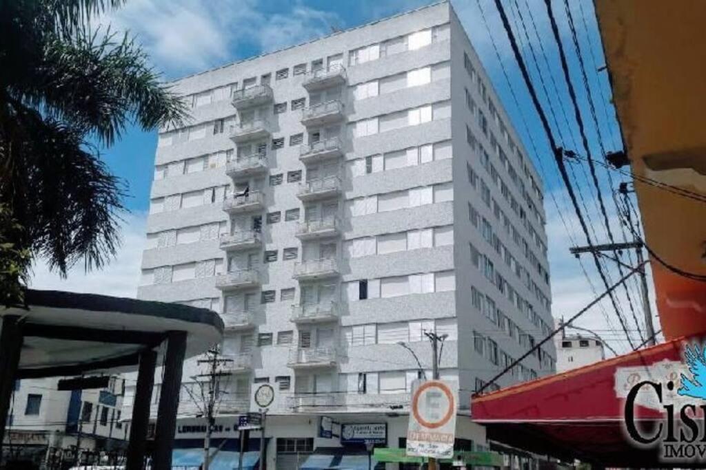 a tall white building with balconies on the side of it at Apto no coração de Serra Negra in Serra Negra