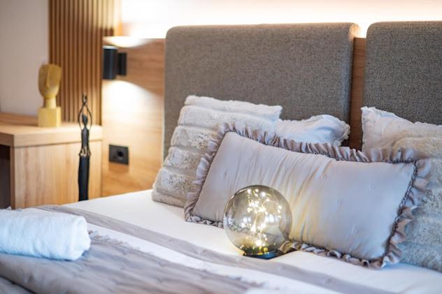 a bed with white pillows and a ball on it at Apartman Joe in Virovitica