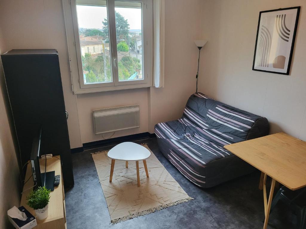 un salon avec un canapé en cuir et une table dans l'établissement Studio reposant et calme, à Agen