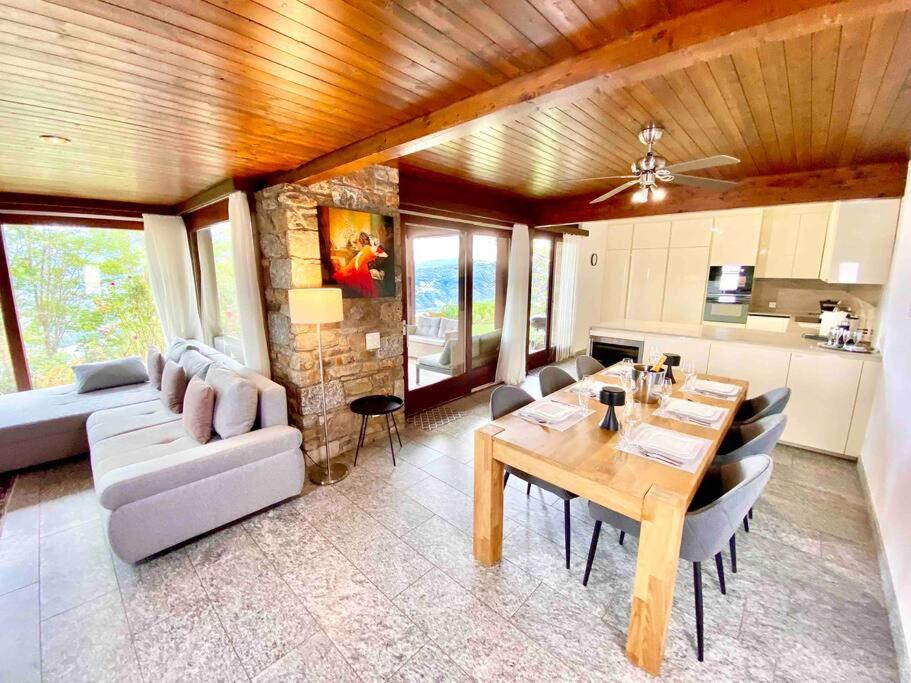 sala de estar con mesa y sofá en [Chalet di lusso]Vista lago + Sauna, en Cimo