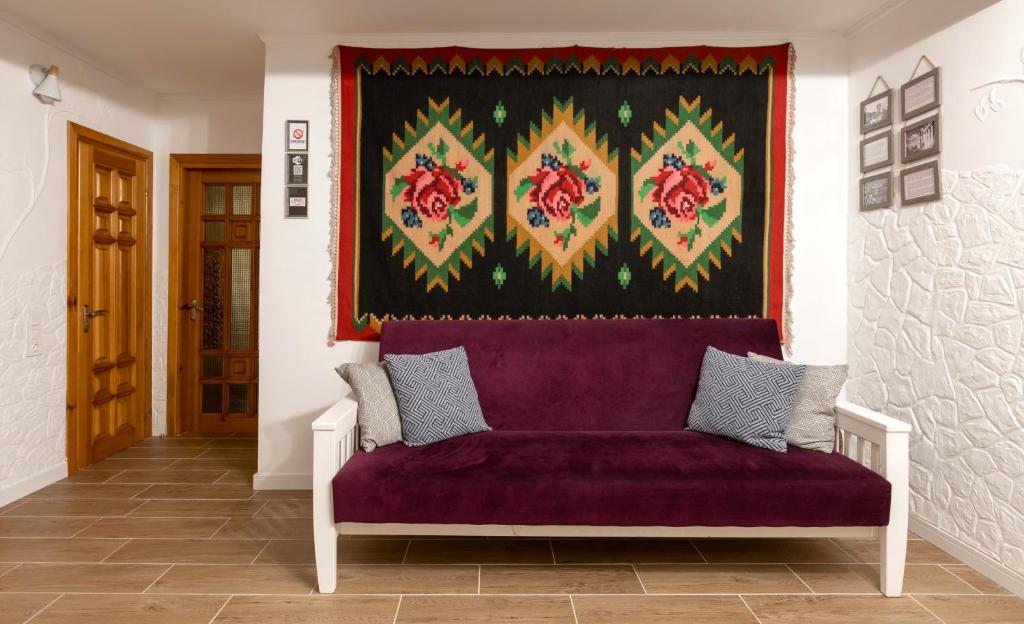 a purple couch in a room with a tapestry at Modern Traditional apartment in Chişinău
