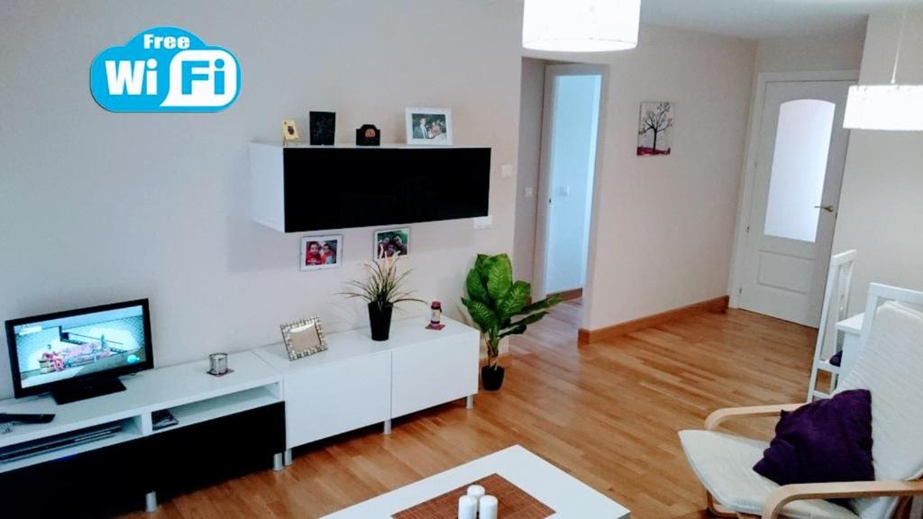 un salon avec une télévision à écran plat sur un mur blanc dans l'établissement Apartment Star, à Rota