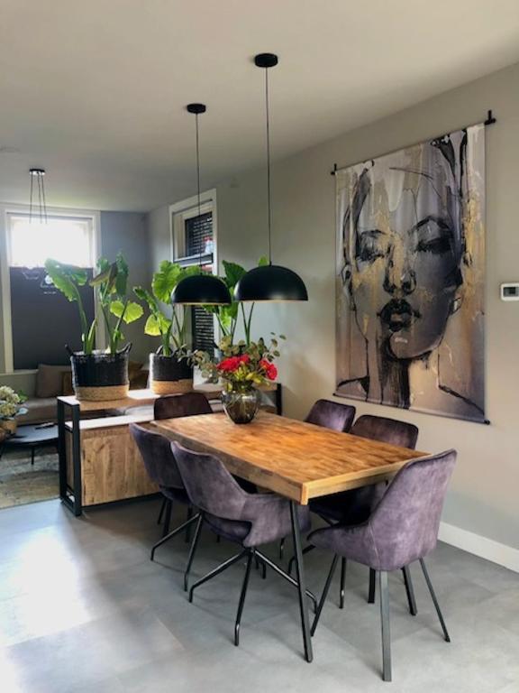 a dining room with a wooden table and purple chairs at welkom bij 5 in Den Ilp