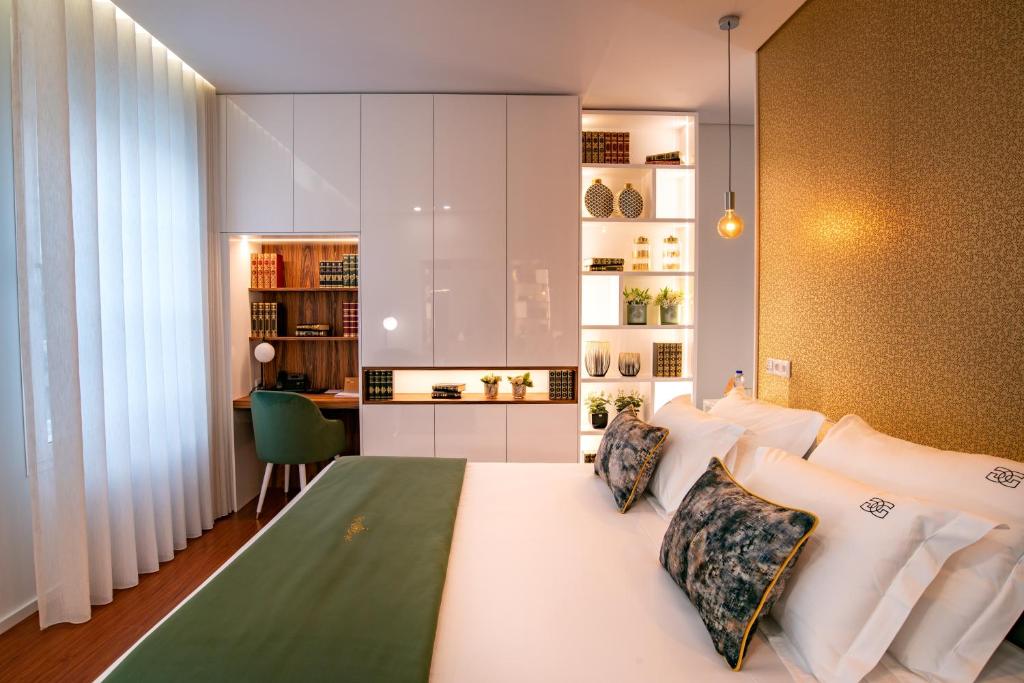 1 dormitorio con 1 cama blanca grande y escritorio en GuimaGold en Guimarães