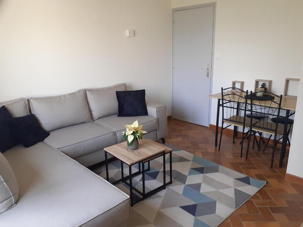 uma sala de estar com um sofá e uma mesa em Gîte Doux repos en campagne em Sundhoffen