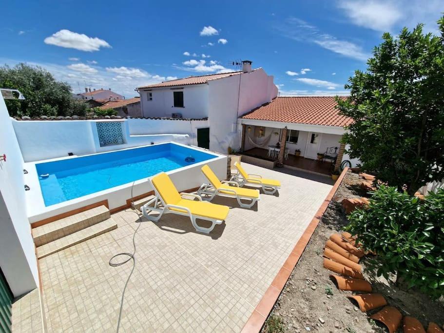 Póvoa de São Miguel的住宿－Casa da Enxota，一个带躺椅的游泳池以及一座房子