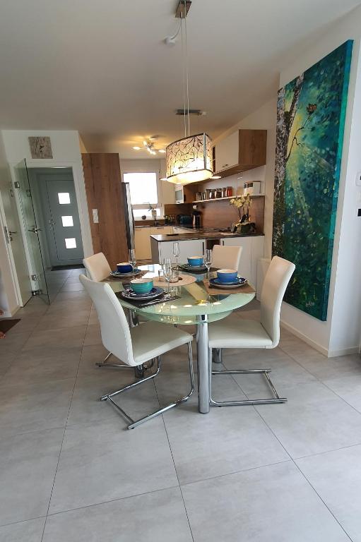 a dining room with a glass table and white chairs at Ein Haus zum Träumen in Bensheim