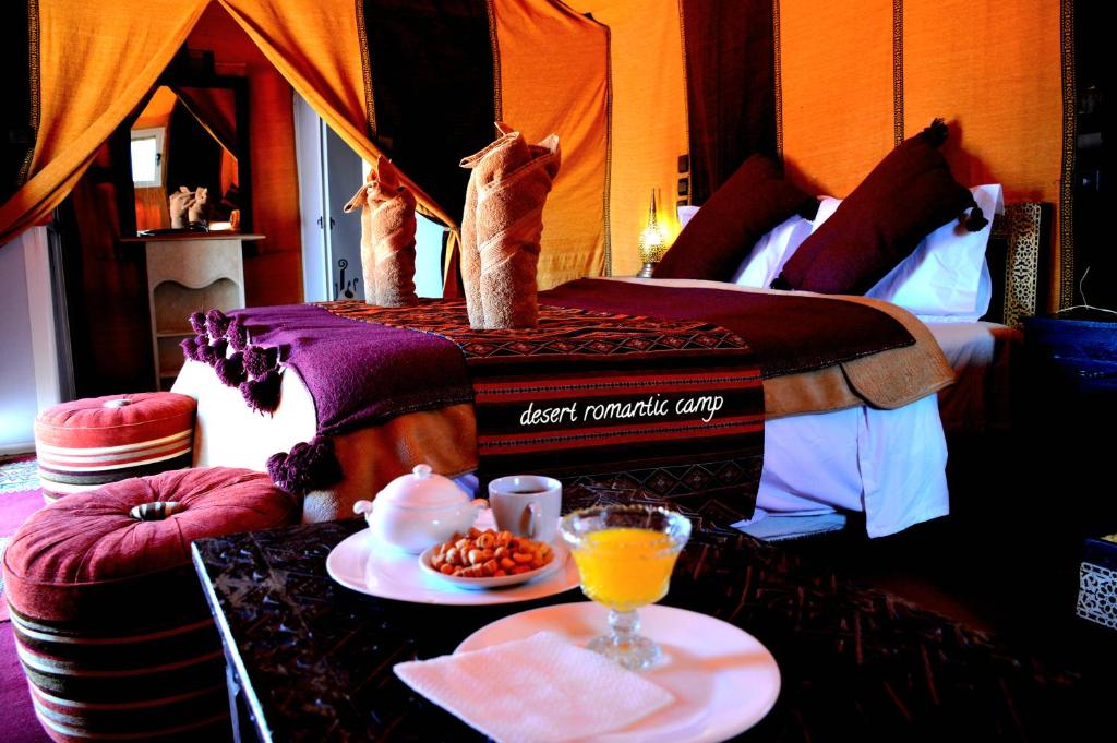ein Bett mit zwei Katzen, die oben drauf stehen in der Unterkunft Luxury Desert Romantic Camp in Merzouga