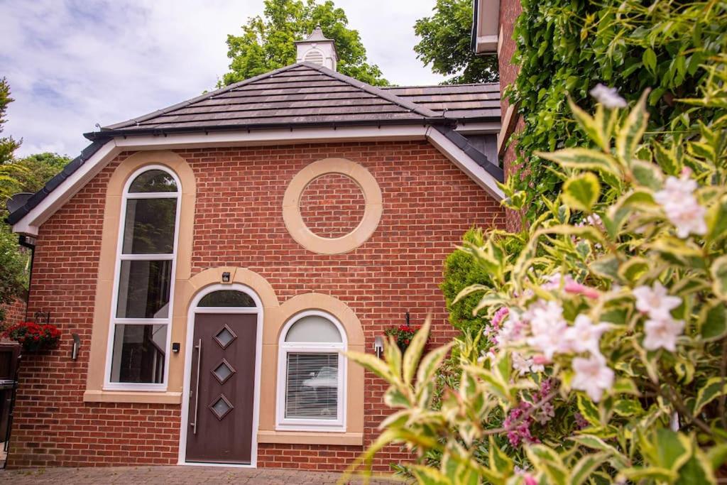a red brick house with a window and a door at Eastfield Retreat with Hot Tub in Stannington