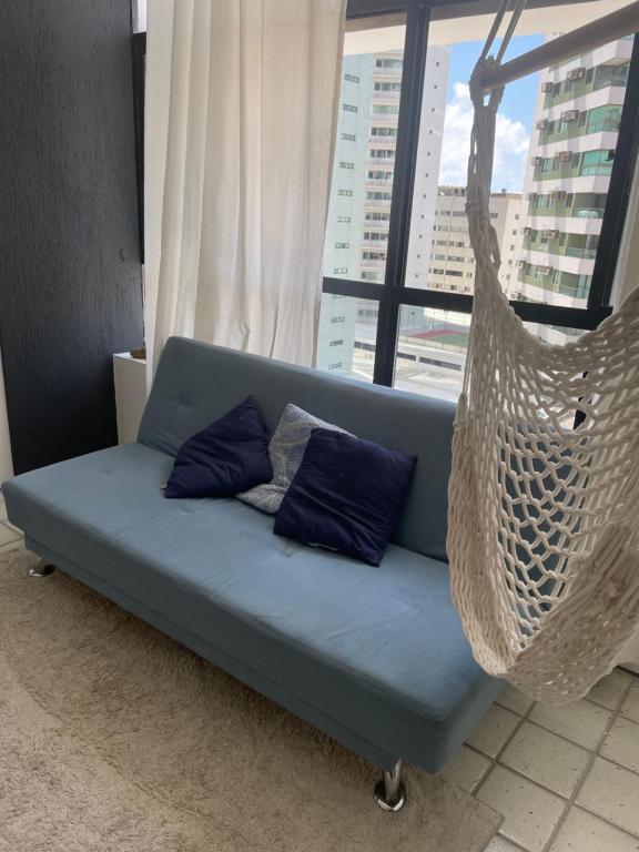 Sofá azul en una habitación con hamaca en Quarto INDISPONÍVEL NO PRESENTE en Recife