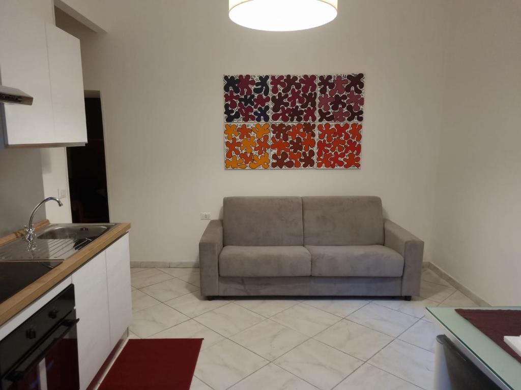 um sofá numa cozinha com um quadro na parede em La Casetta di Oppi em Nápoles
