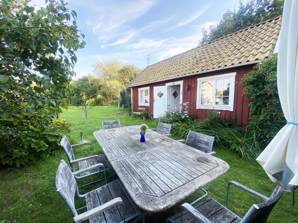 uma mesa e cadeiras num quintal com uma casa em Cozy cottage in Vejbystrand near the beach em Vejbystrand