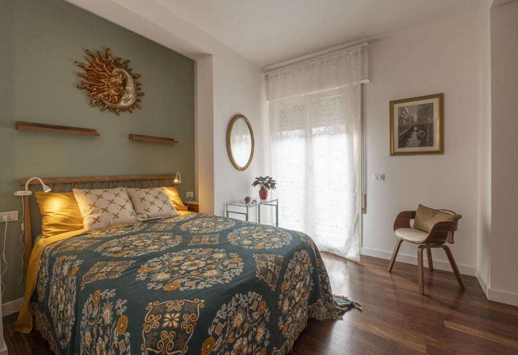 a bedroom with a bed and a chair and a window at Apartment Sun&Moon in Venice in Mestre