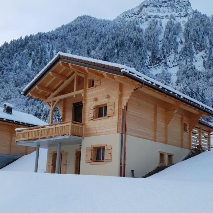 une maison en bois avec une montagne enneigée en arrière-plan dans l'établissement Chalet Génie des Alpages, 8 personnes, proche stations, à Entremont
