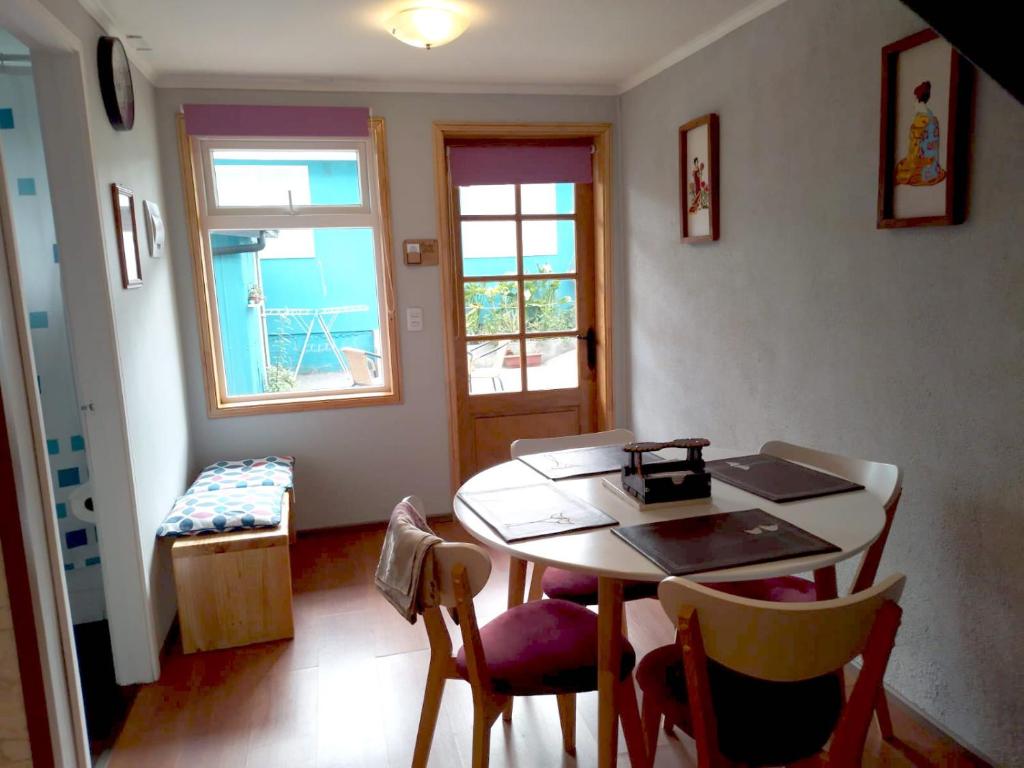 a dining room with a table and chairs and a window at CASA PALI 2 in Puerto Montt