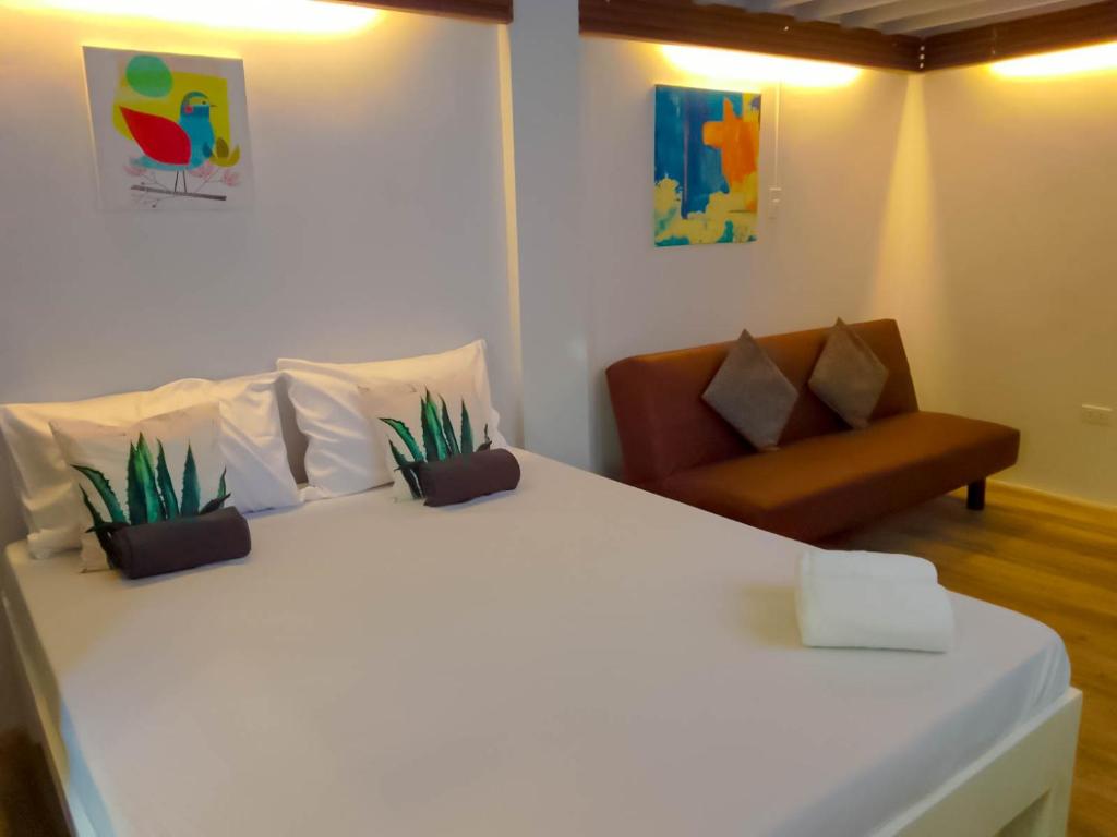 a bedroom with a white bed and a chair at Coco Cavana Resort in Batangas City