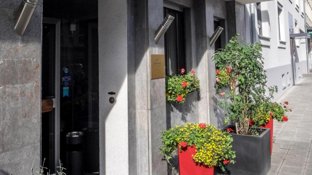 un edificio con macetas de flores a un lado. en Hotel Fackelmann, en Núremberg