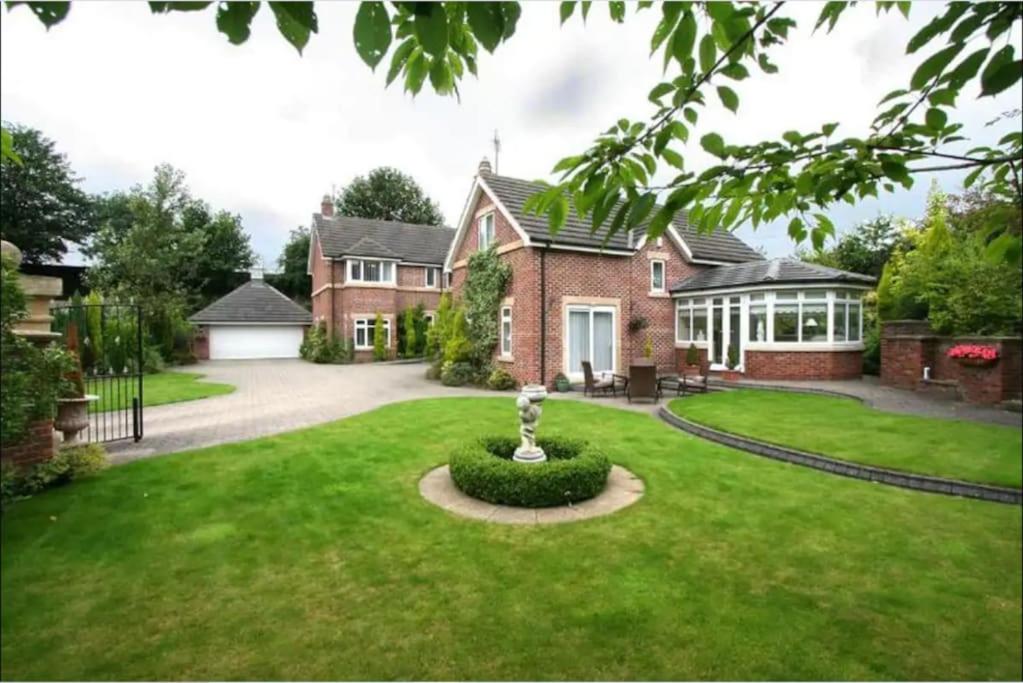 a house with a green lawn in front of it at Eastfield Lodge with Hot Tub in Stannington