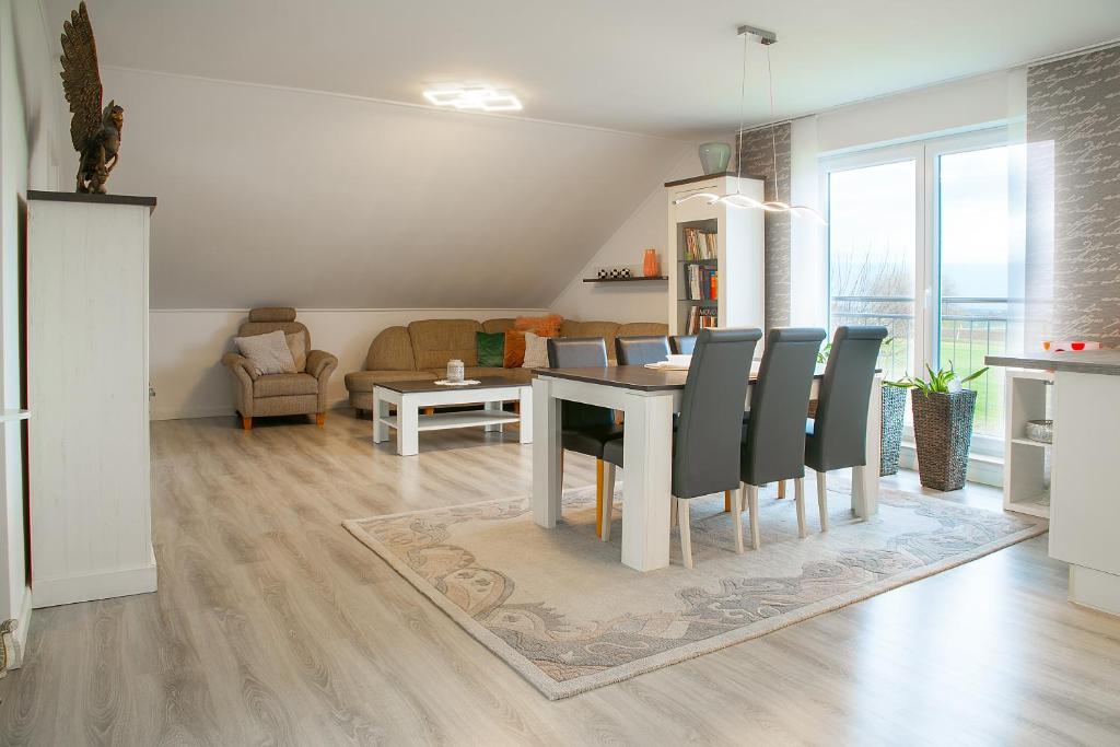 comedor y sala de estar con mesa y sillas en Ferienwohnung am Feld, en Vettweiß