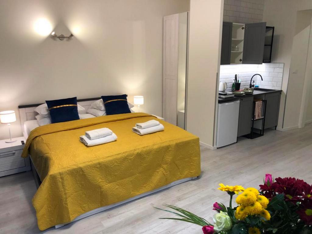 a bedroom with a yellow bed with towels on it at Central Cracow Apartments in Kraków