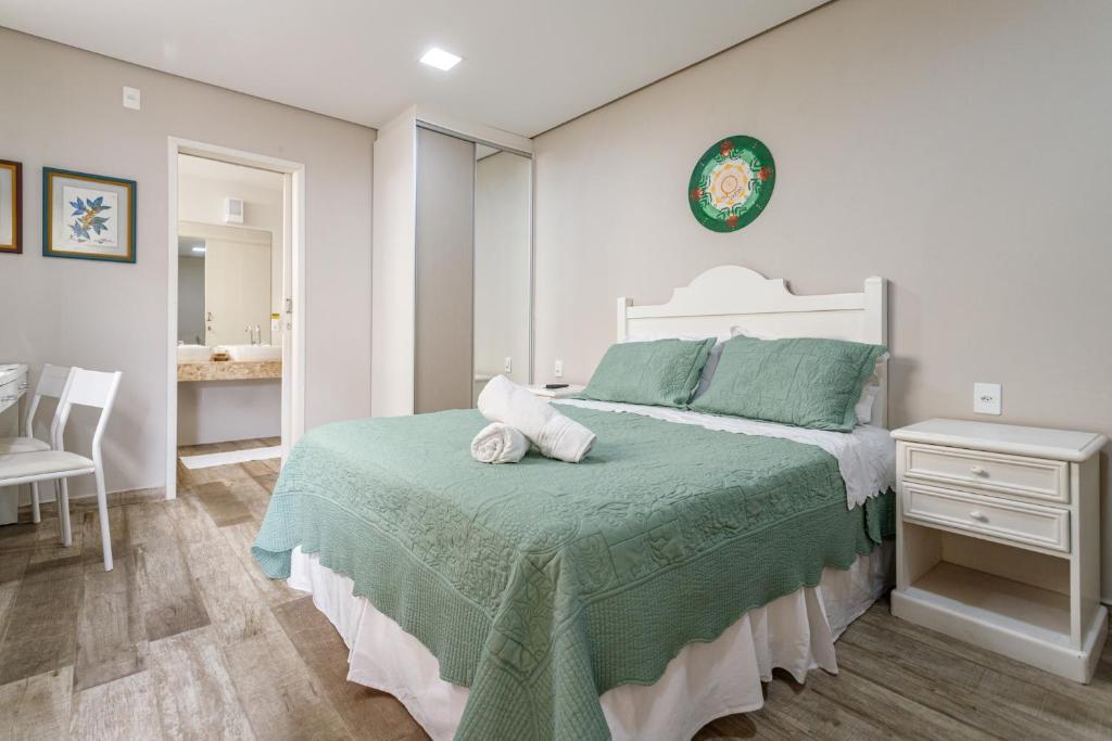 佛羅安那波里的住宿－Pousada Vô Santino，一间卧室配有一张带绿毯的大床