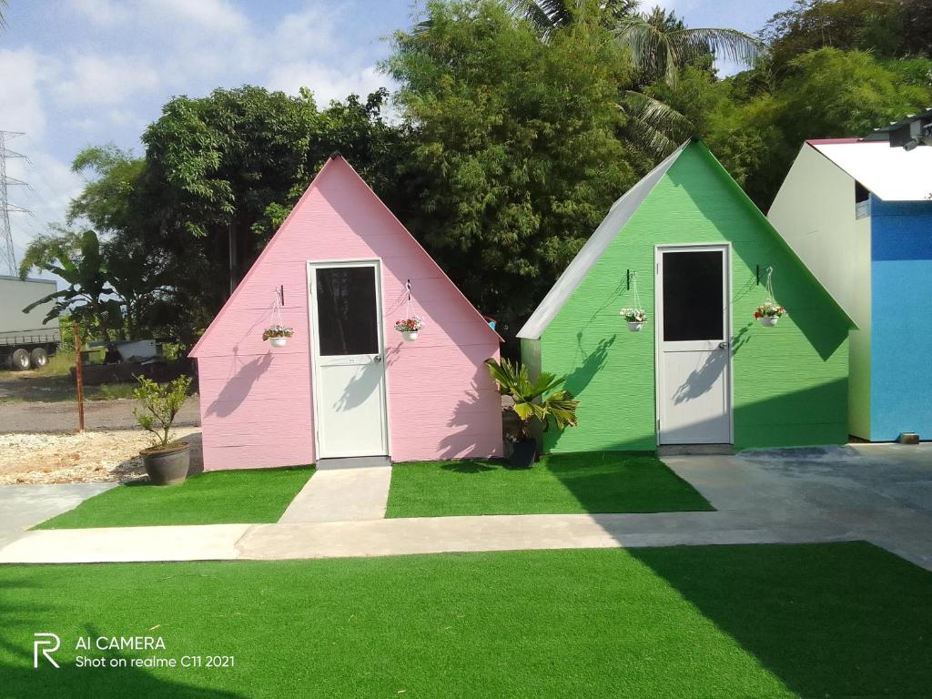 dos casas pintadas en diferentes colores en la hierba en IT SWISS GARDEN en Perai