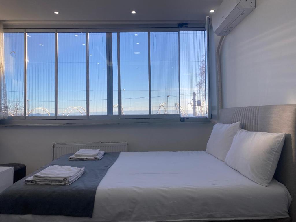 a bed in a room with a large window at Amida Family pansiyon in Istanbul