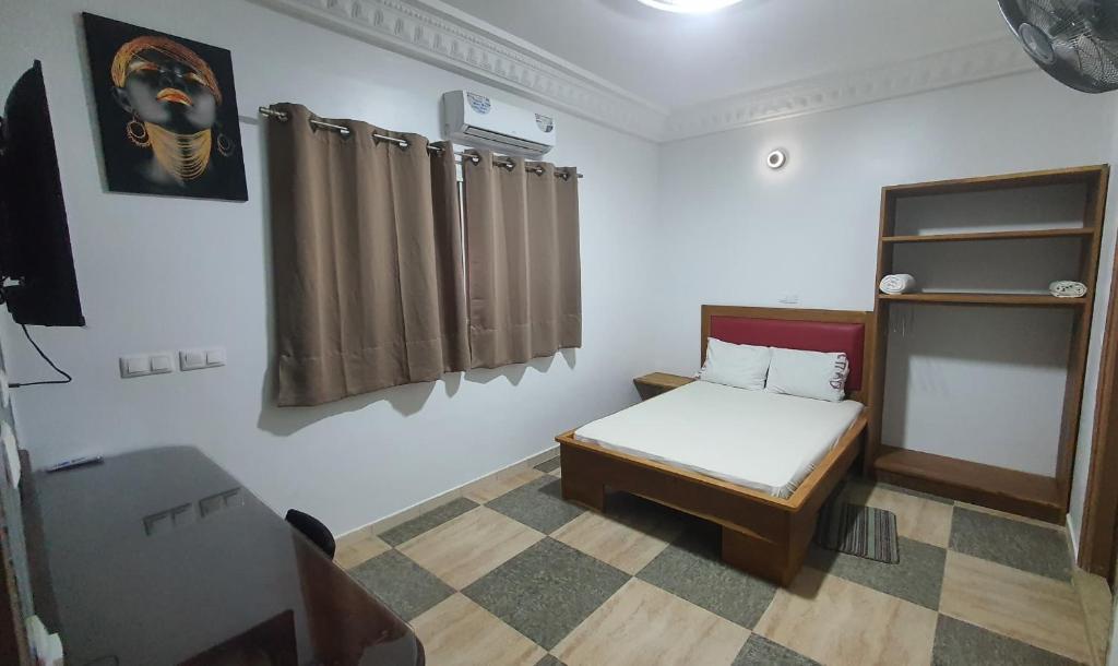 Habitación pequeña con cama y ventana en Résidence abdou diouf en Dakar