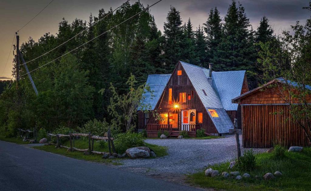 een hut in het bos met de lichten aan bij Au Sommet du Fjord in Sacré-Coeur-Saguenay