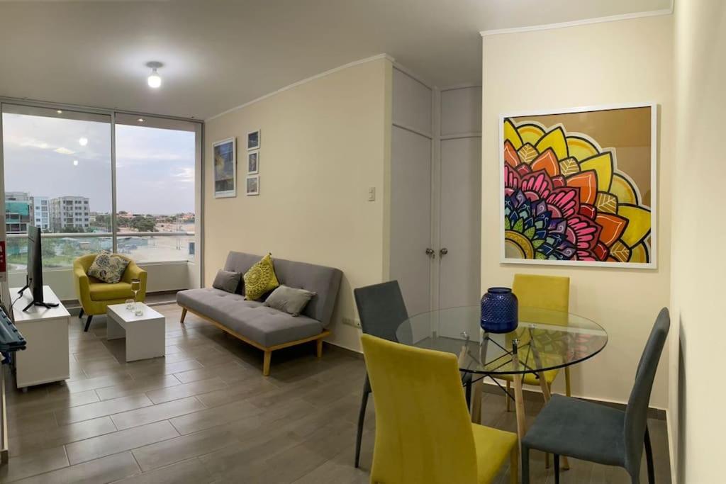 ein Wohnzimmer mit einem Glastisch und gelben Stühlen in der Unterkunft Departamento de Estreno SEMREQ in Piura